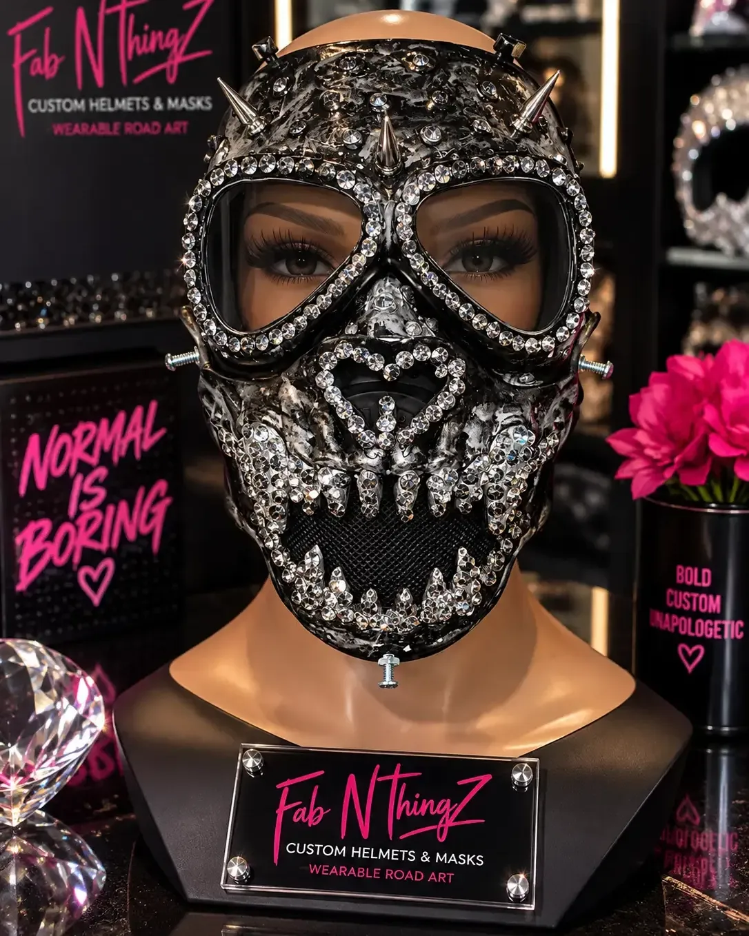 Black and gunmetal gas-style mask with crystal-lined eye rims, a blinged skull mouth, and metal spikes across the crown