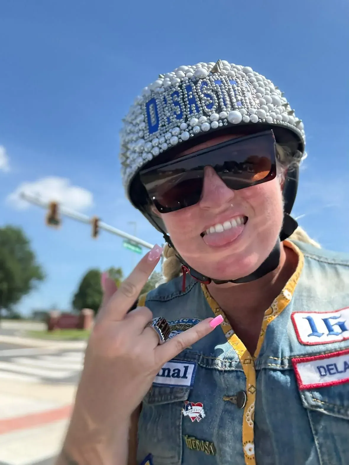 Smiling rider wearing a crystal covered helmet and denim vest
