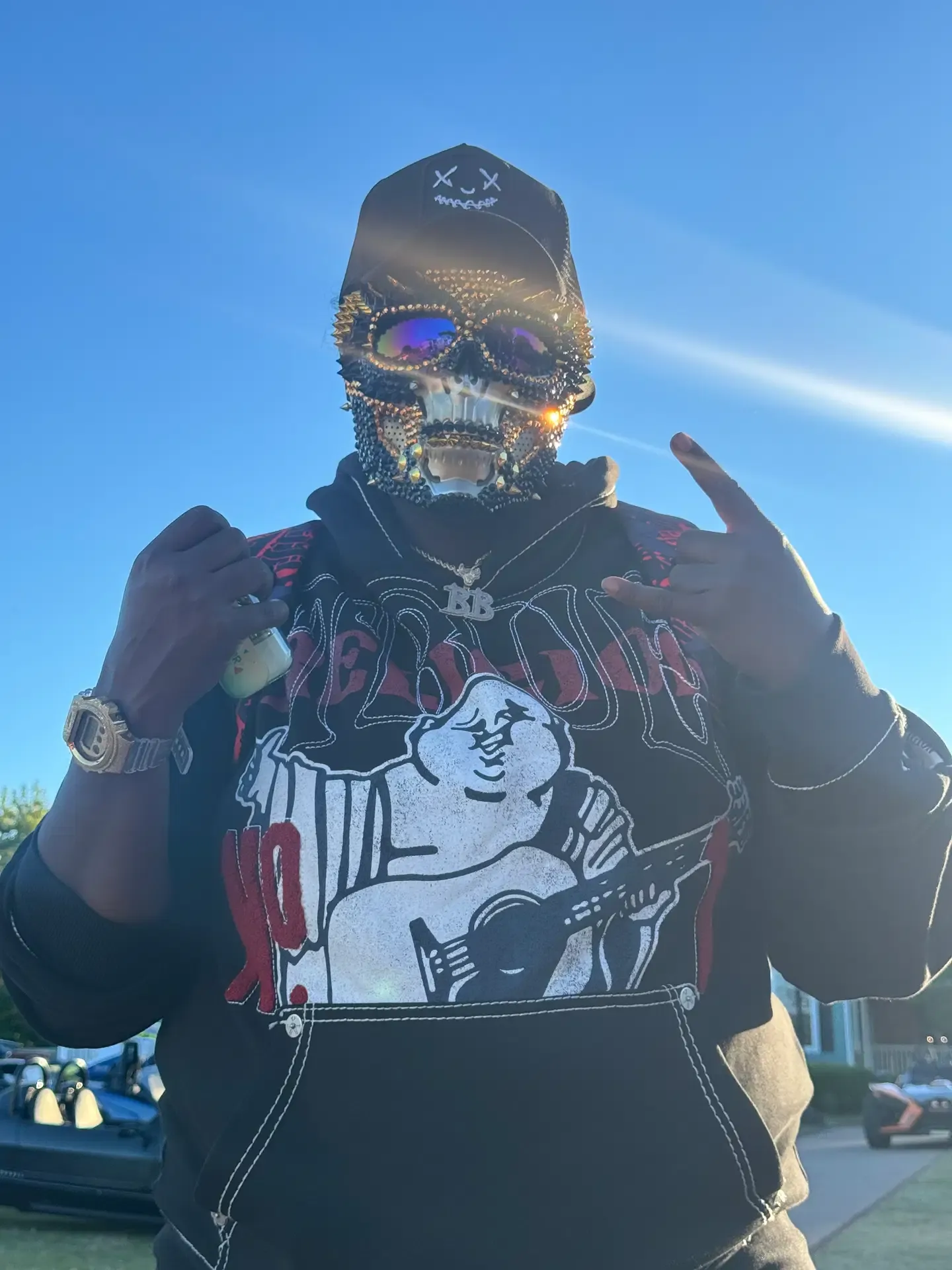 Festival attendee wearing a jeweled black skull mask outdoors at 3WK