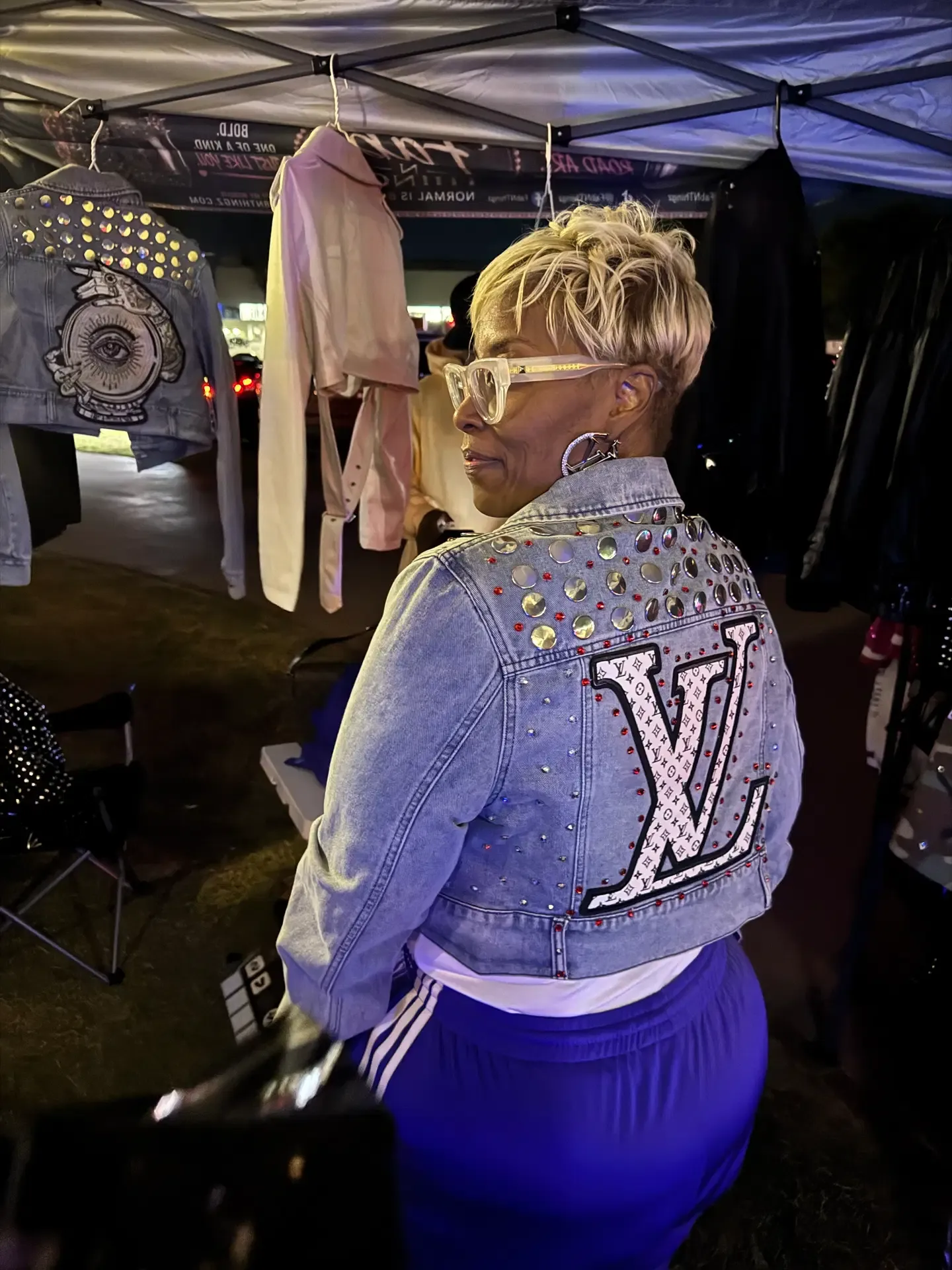 Attendee modeling a crystal-embellished denim jacket at the FAB N THINGZ booth
