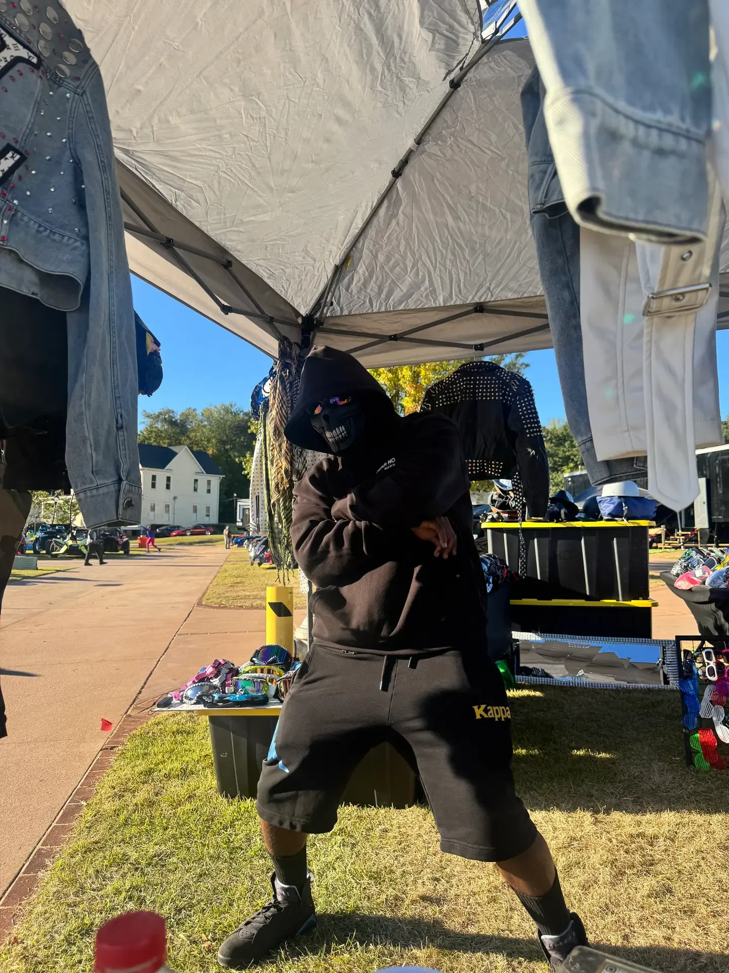 Festival attendee in a skull face covering at the outdoor vendor booth